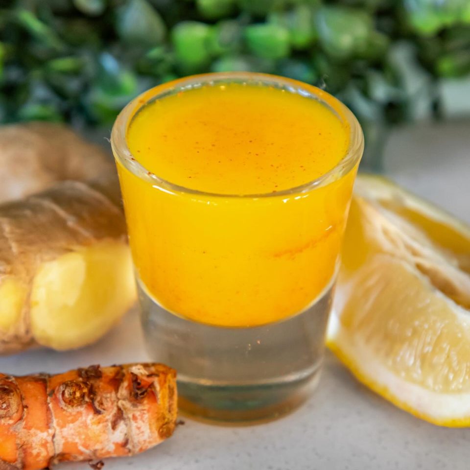 A vibrant orange juice shot from Juice Parlor NoHo, with ginger, turmeric, and lemon.
