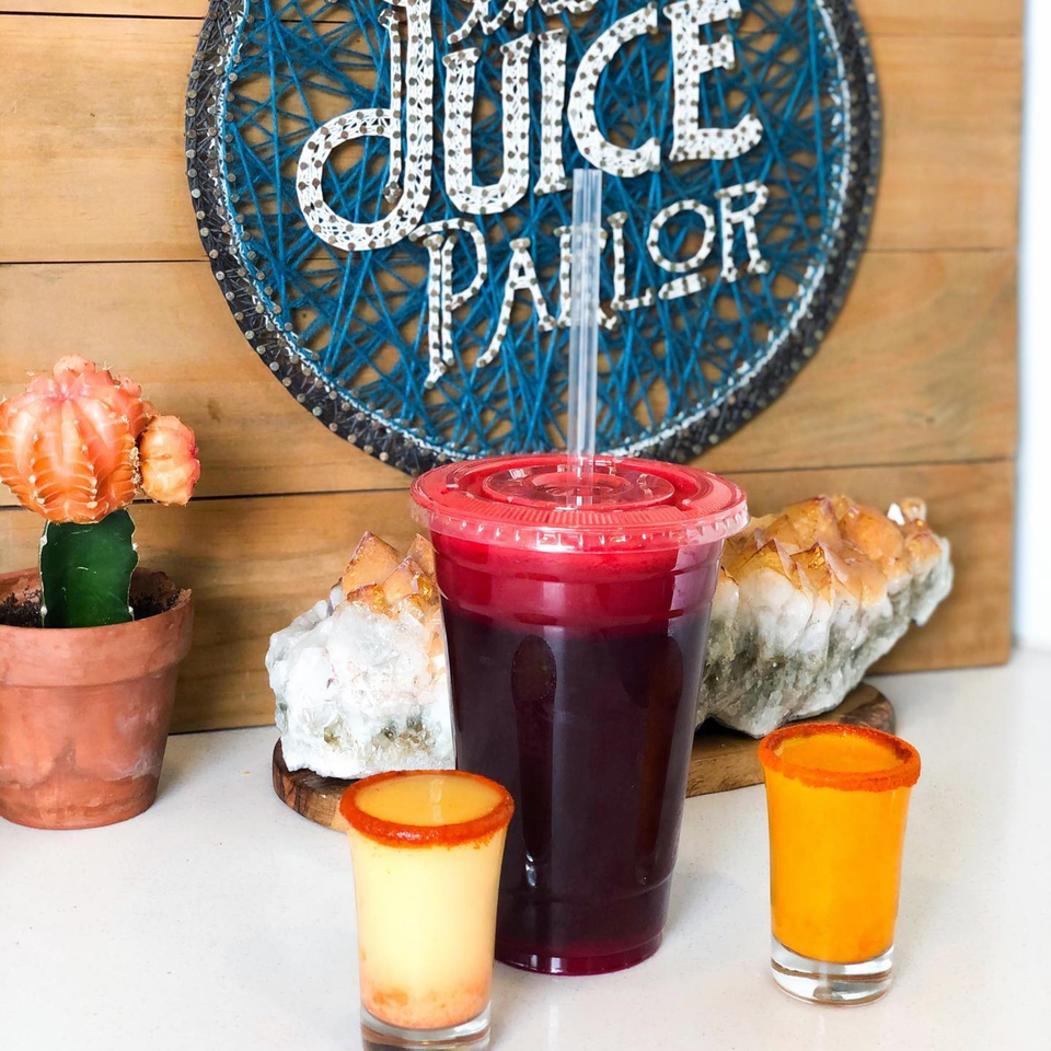 Juice Parlor NoHo drinks: a large red juice, two small yellow shots, and a cactus.